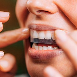 Patient putting whitening strip on