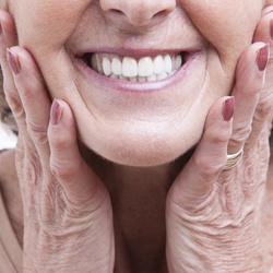Woman smiling after getting all on four dentures