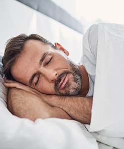 Man sleeping soundly with nightguard for bruxism in Assonet