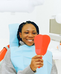 Woman at dentist looking in dental mirror