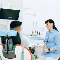 Man speaking with dentist at checkup
