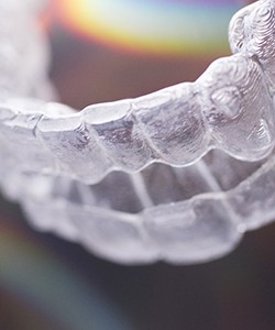 A clear aligner lying on a table that is used by an individual receiving ClearCorrect Clear Braces in Assonet