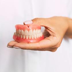 Dentist holding set of full dentures