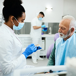A dentist answering her patient’s denture questions