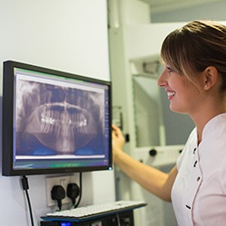 Dentist looking at a patient’s dental X-rays before dental implant placement