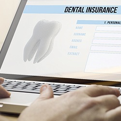 Person filling out dental insurance information on a laptop