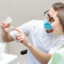 Dentist showing a patient how dental implants work