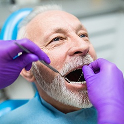 Dentist examining a patient’s mouth after dental implant surgery