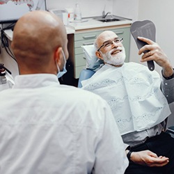 Patient admiring his smile after getting dental implants