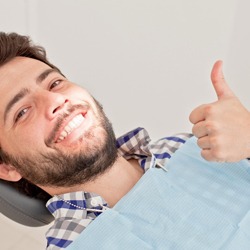 Man smiling giving thumbs up after metal free dental restoration