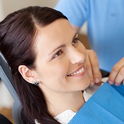 Smiling woman in dental chair for dental checkup and teeth cleaning
