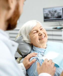 a patient smiling after undergoing implant salvage treatment