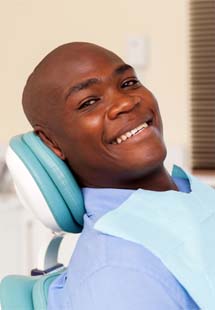 Woman in dental chair for preventive dentistry giving thumbs up