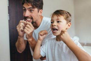 parent and child brushing and flossing their teeth