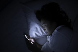 person on their phone while laying in bed